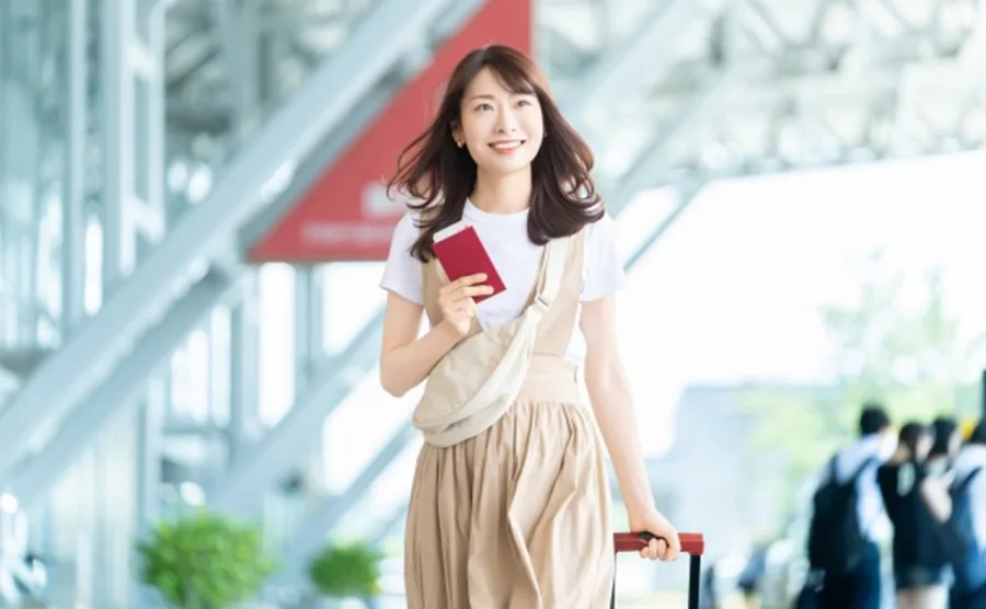 パスポート片手に、旅行でストレス発散しようとしている日本人女性の画像