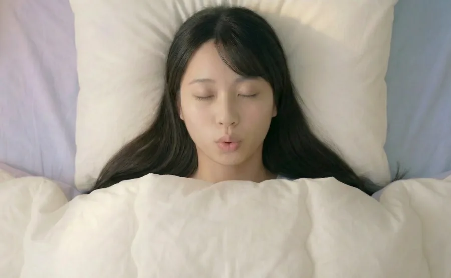 口からフーっと息を吐いている女性の画像