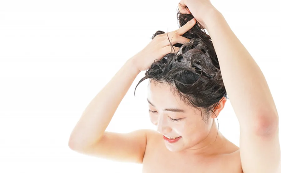 若い女性がシャンプーしている画像