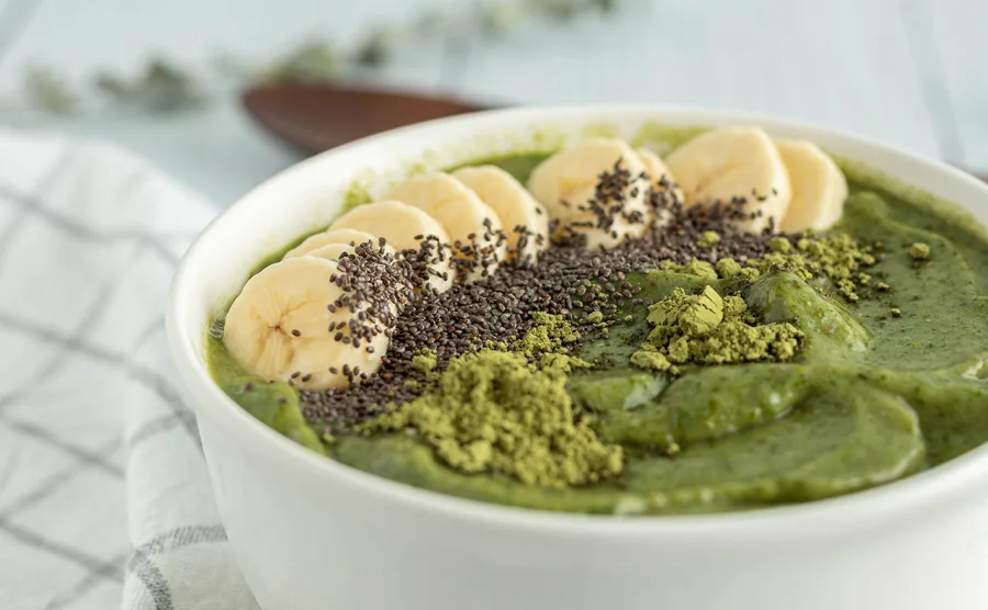 モリンガパウダーを混ぜたヨーグルトにバナナとチアシードをのせた朝食の画像