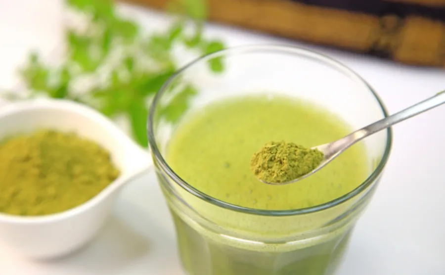 モリンガの粉末パウダーを飲み物に入れている画像