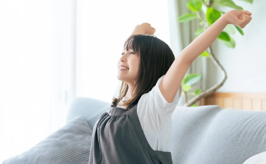 生活習慣の良さそうな健康的な女性が伸びをしている画像