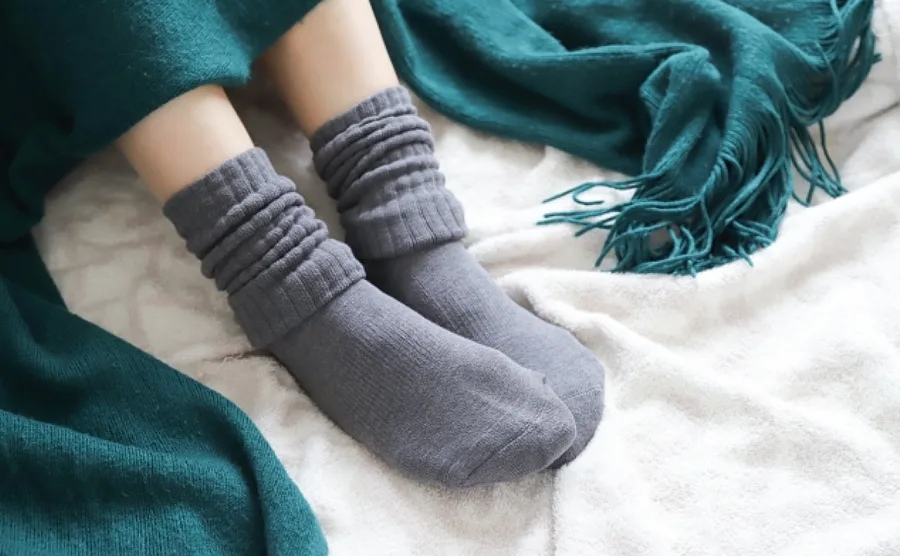 ネイビーの靴下を履いている女性の足が写っている冷え性のイメージ画像