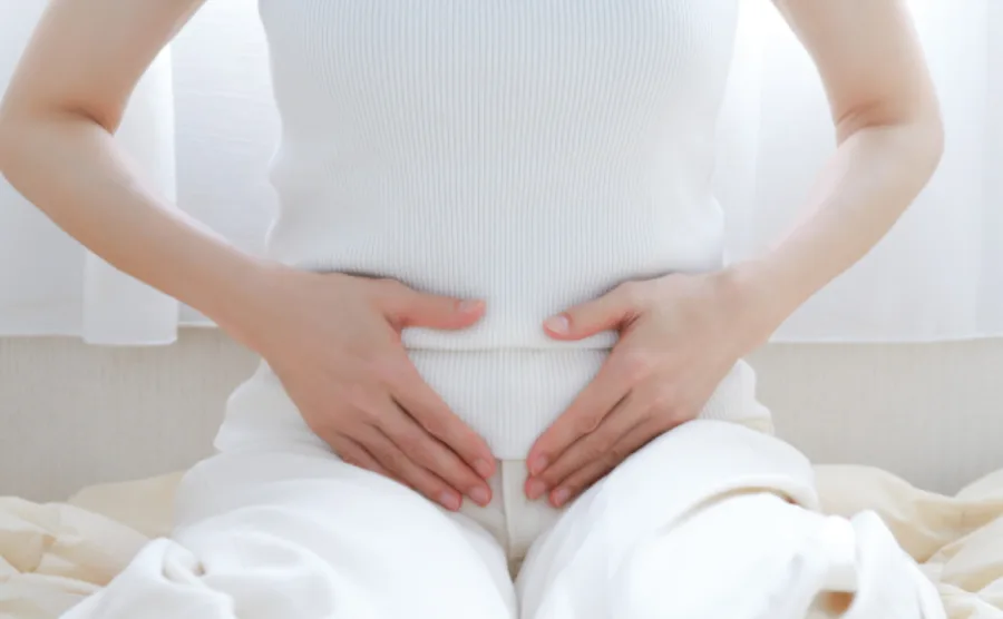 優しくお腹をさすっている女性の画像