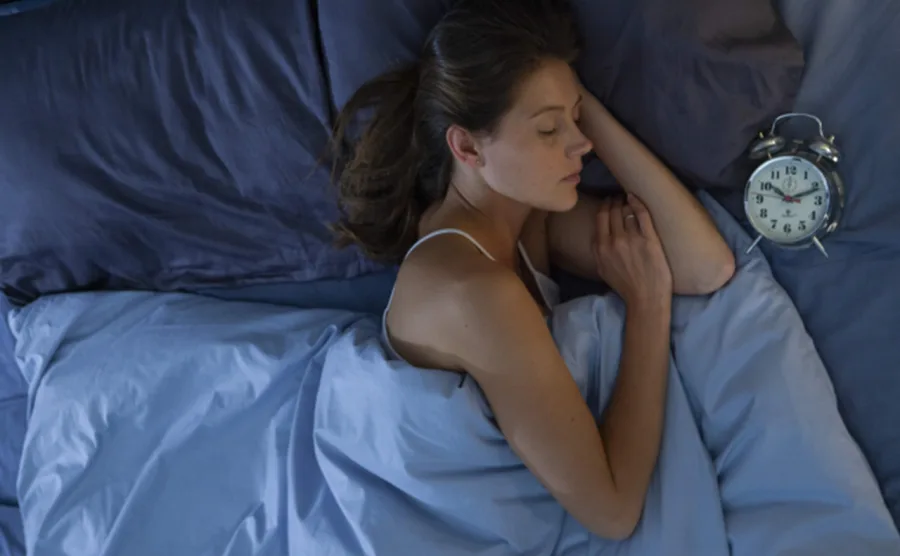 ベッドで横になり、入眠している白人女性の画像