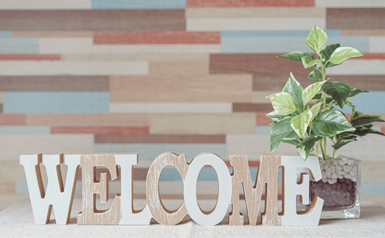 自宅サロンの入り口で、小さな観葉植物とwelcomeとカットした木製のオーナメントの画像
